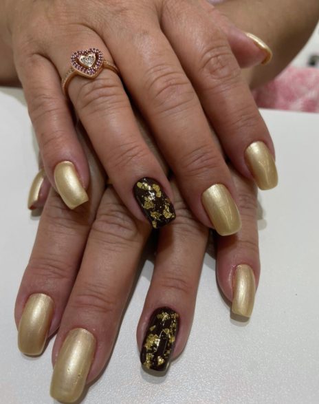 Unhas douradas com unha decorada em folha de ouro
